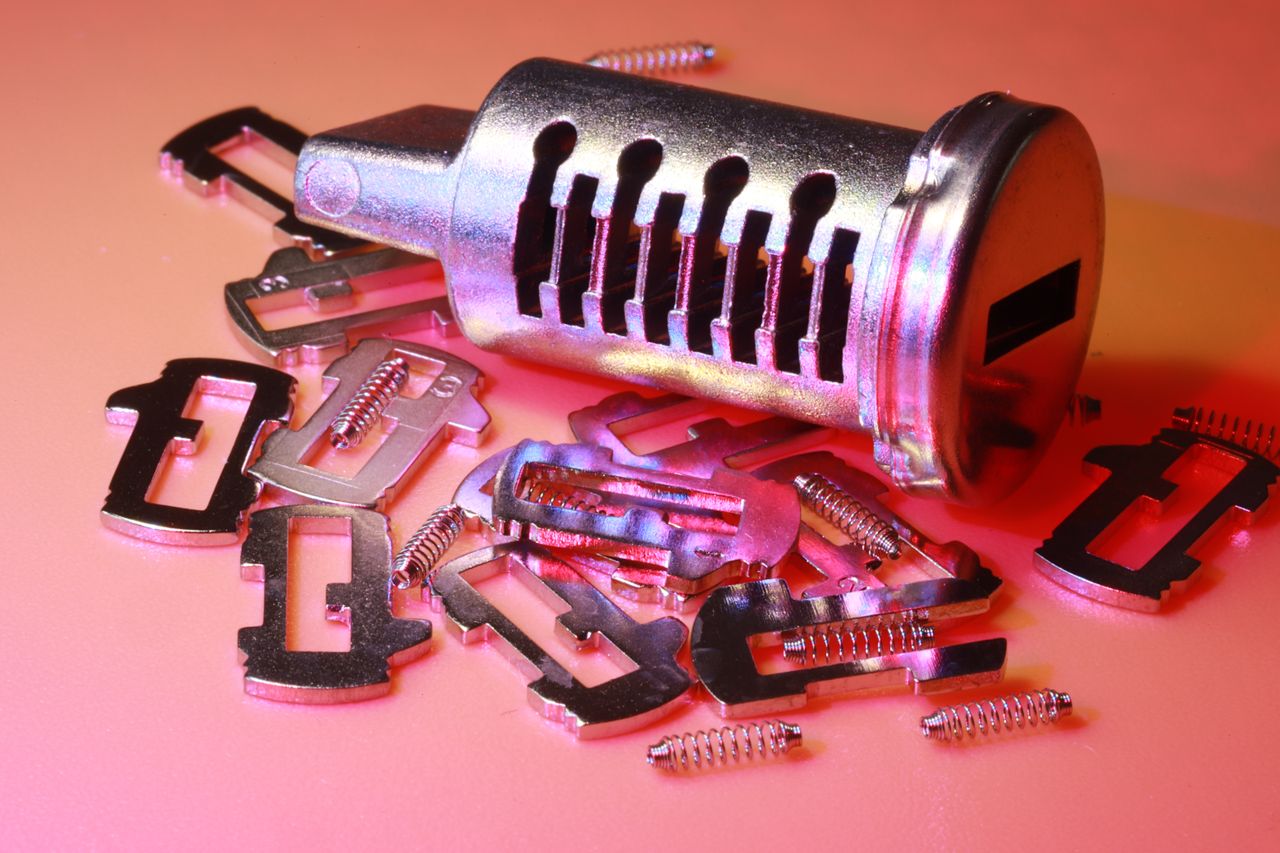 The Art of Drawing Readers In: Your attractive post title goes here Detailed image of a disassembled lock cylinder and its metal components on a colored surface.